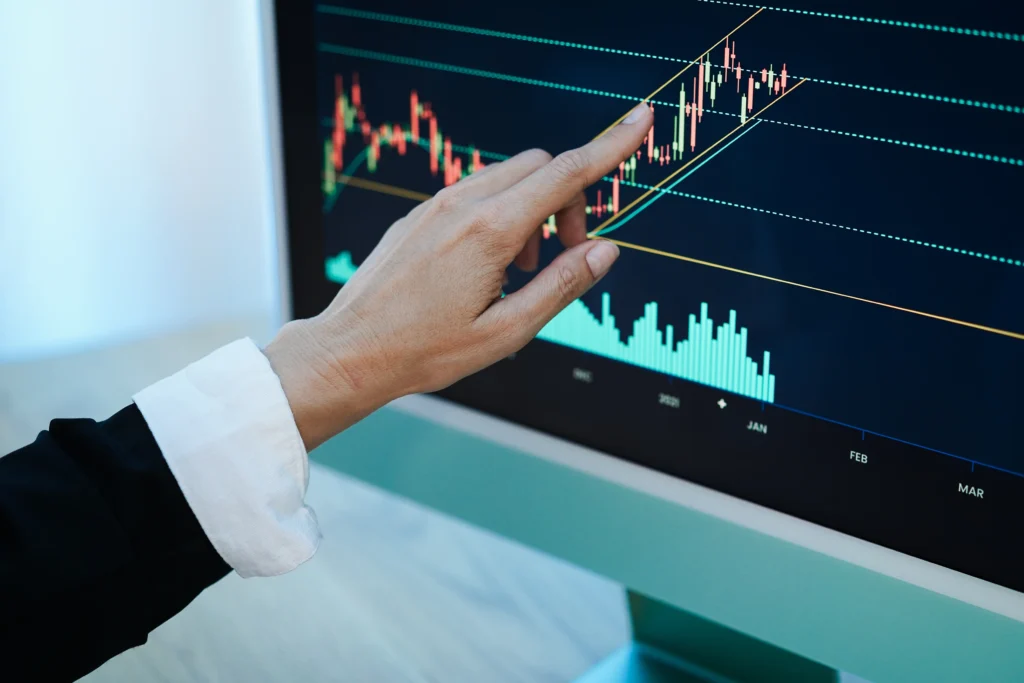 a hand pointing at a graph on a computer screen